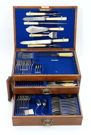 A golden oak cased part canteen of silver plate cutlery