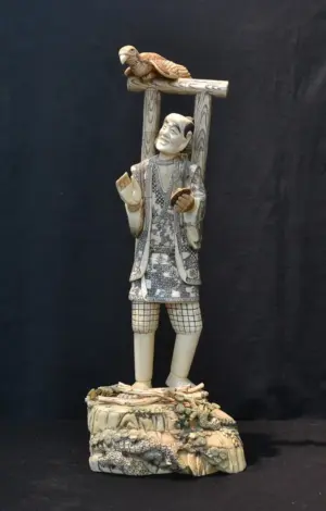 CARVED BONE FIGURE OF MAN WITH BIRD