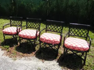 FOUR BLACK PAINTED RATTAN ARMCHAIRS