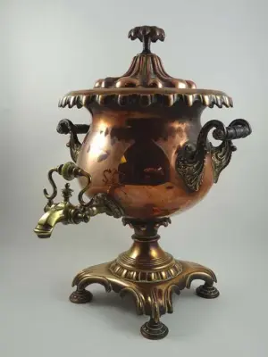 An ornate WM IV copper and bronze four footed urn