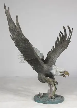 BRONZE EAGLE IN FLIGHT GRASPING FISH IN TALON